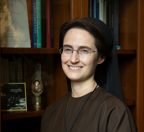 カティア・パセリーニ学長がヘミングソンセンターの窓の前で立っている。